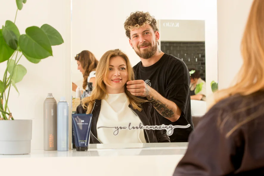 Friseur zeigt einer Frau ihre Frisur