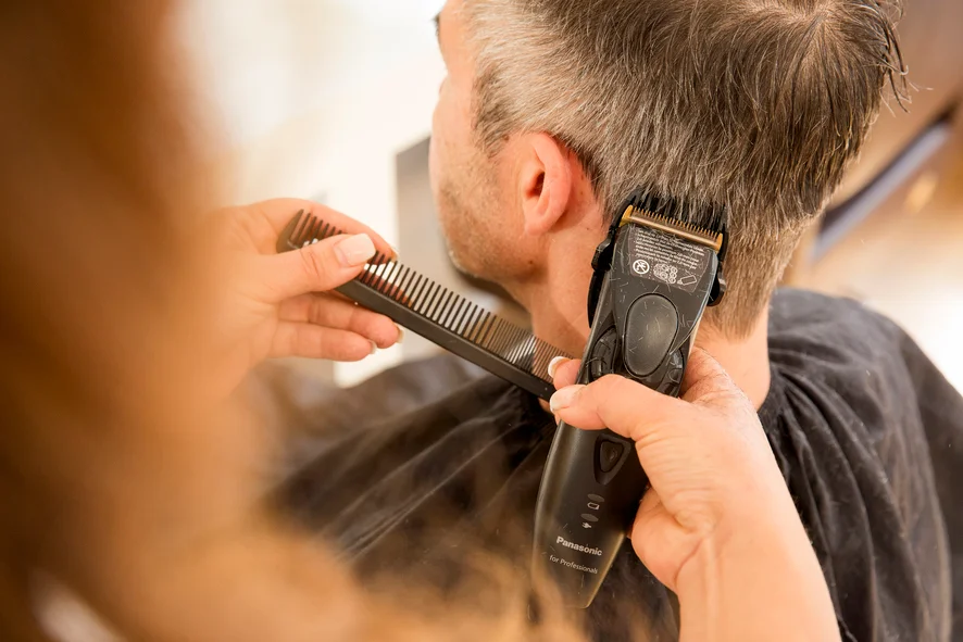 Einem Mann werden die Haare geschnitten